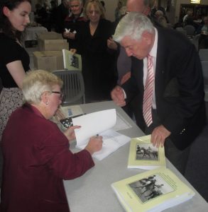 Anne Field Signing Barry Parkes's Book. Barry is a retired racing journalist.